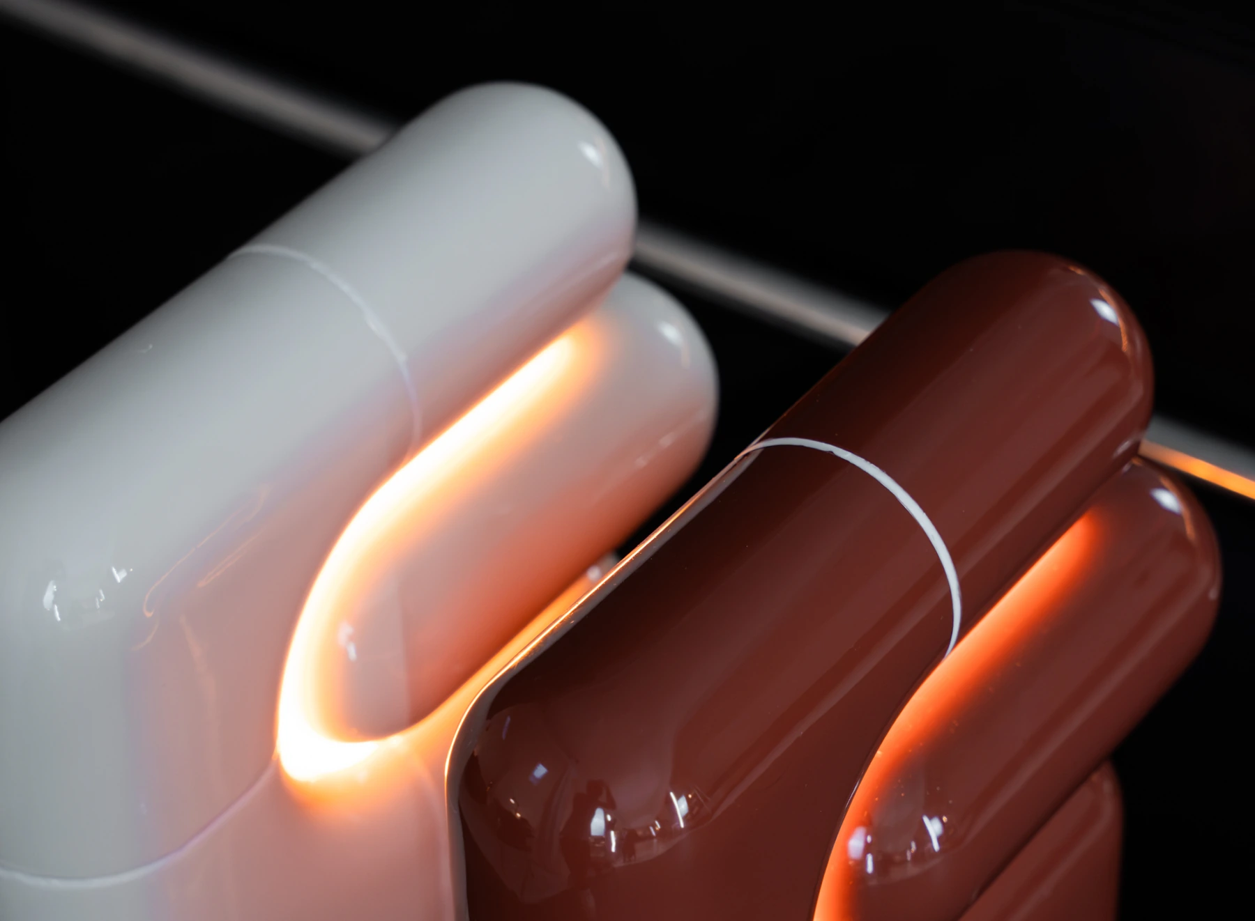 Two U·021 lamps in high gloss, white and deep red, lit, close up